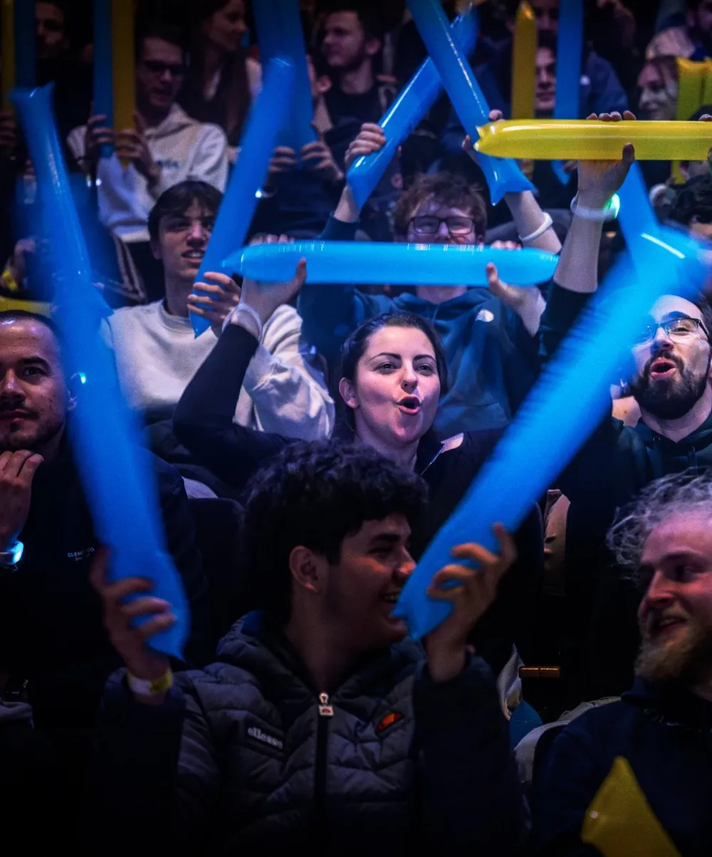 Le public en tribune agite des bâtons gonflables bleus et jaunes.