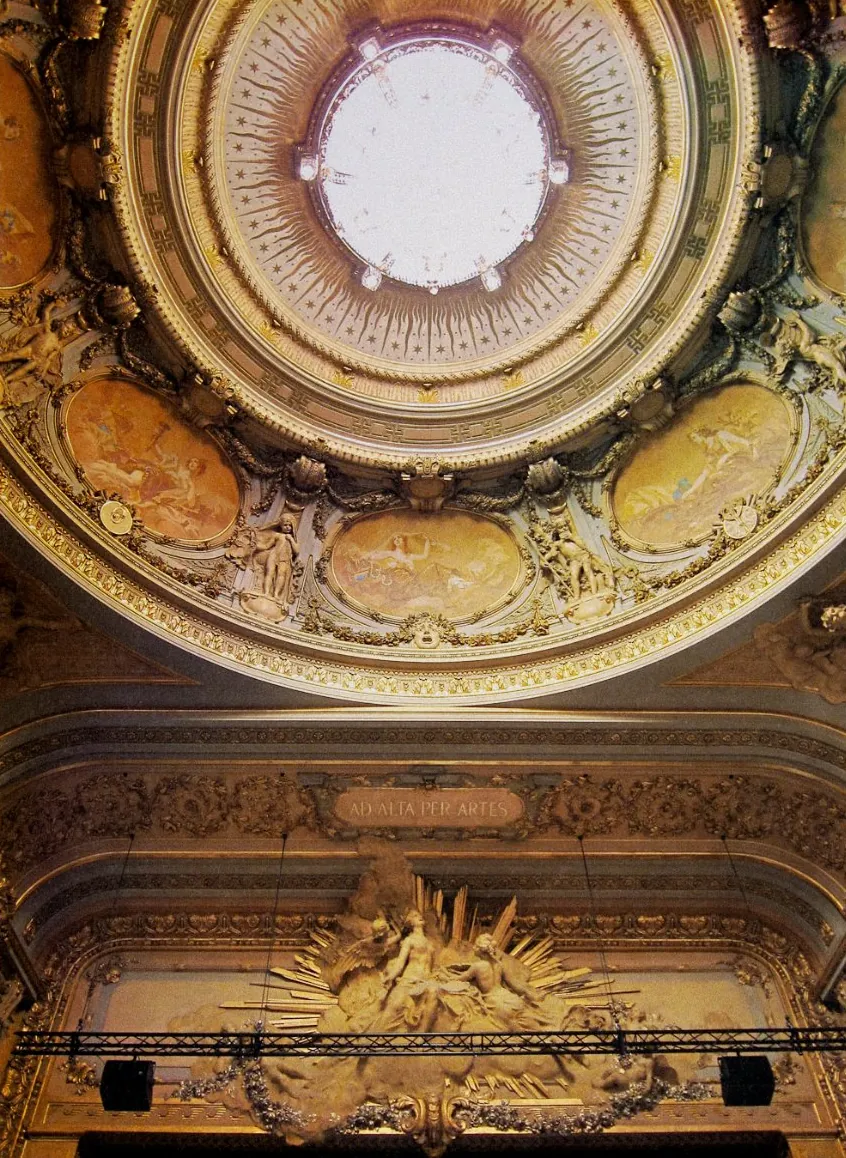 La coupole peinte de la salle et la devise Ad alta per artes au-dessus de la scène.